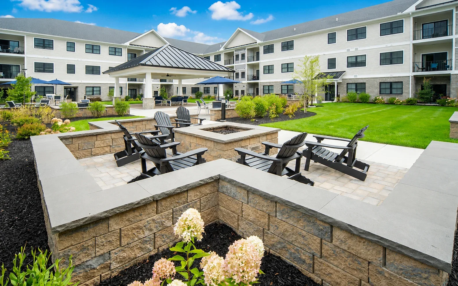 blue skyes Courtyard with a firepit, Adirondack chairs, and a gazebo beside the apartment building